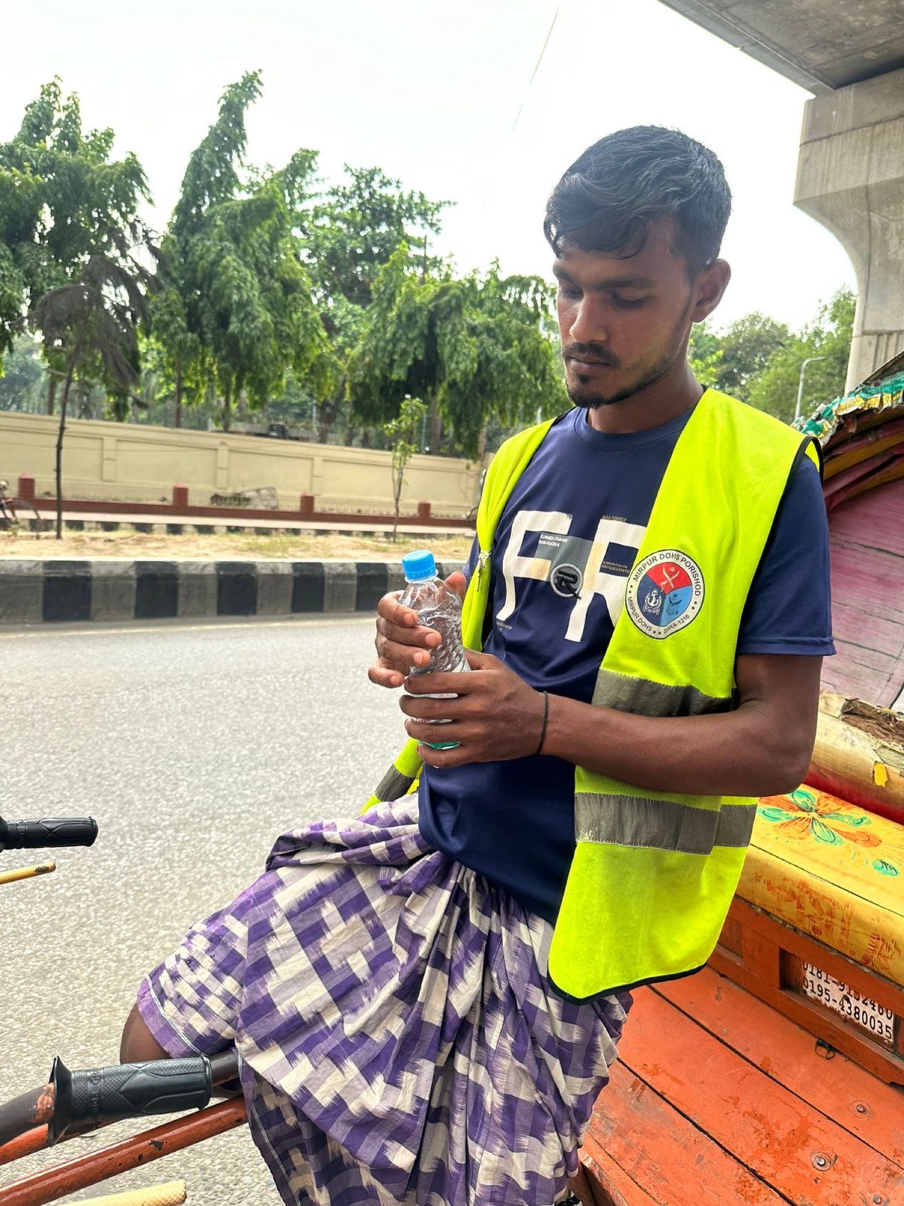 A volunteer holding bottled water during Hashi Ekshathe’s heatwave response
